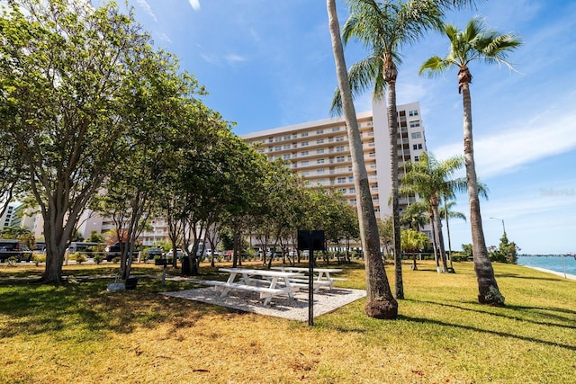 surrounding community featuring a water view and a lawn