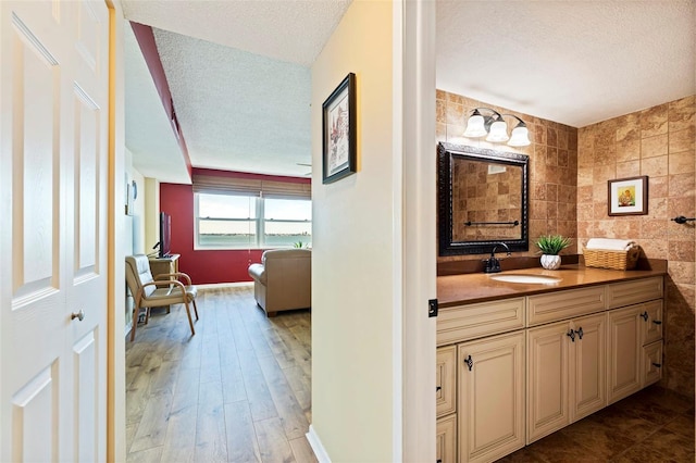 bathroom with a textured ceiling, hardwood / wood-style flooring, and vanity