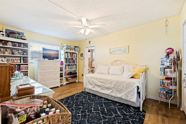 bedroom with ceiling fan, a textured ceiling, and hardwood / wood-style flooring