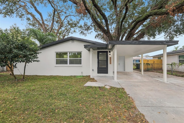 view of front of house with a carport and a front lawn