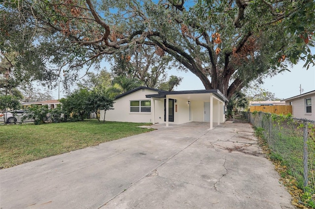 ranch-style house with a carport and a front lawn