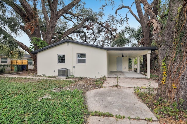 back of house featuring central AC unit, a carport, and ceiling fan