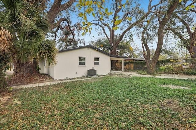 view of side of home with a carport, central AC unit, and a yard