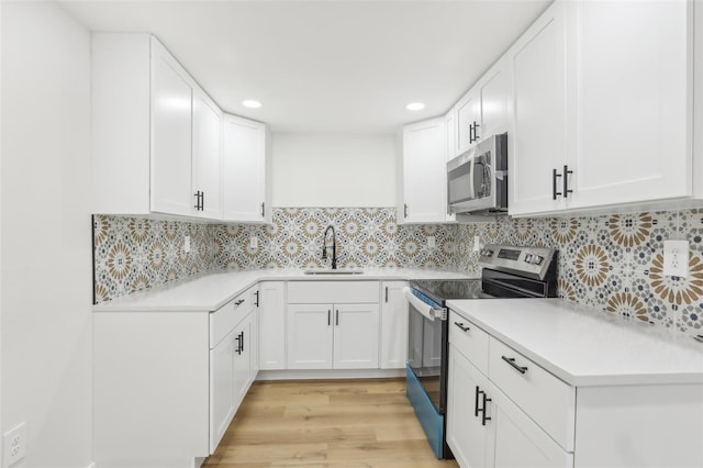 kitchen with sink, white cabinetry, and appliances with stainless steel finishes