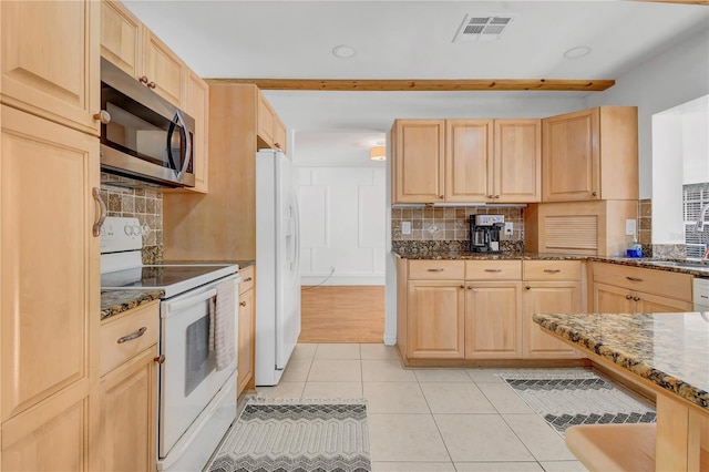 kitchen featuring light tile patterned flooring, dark stone countertops, backsplash, light brown cabinets, and white appliances