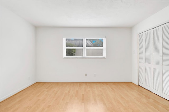 unfurnished bedroom with a closet and light wood-type flooring