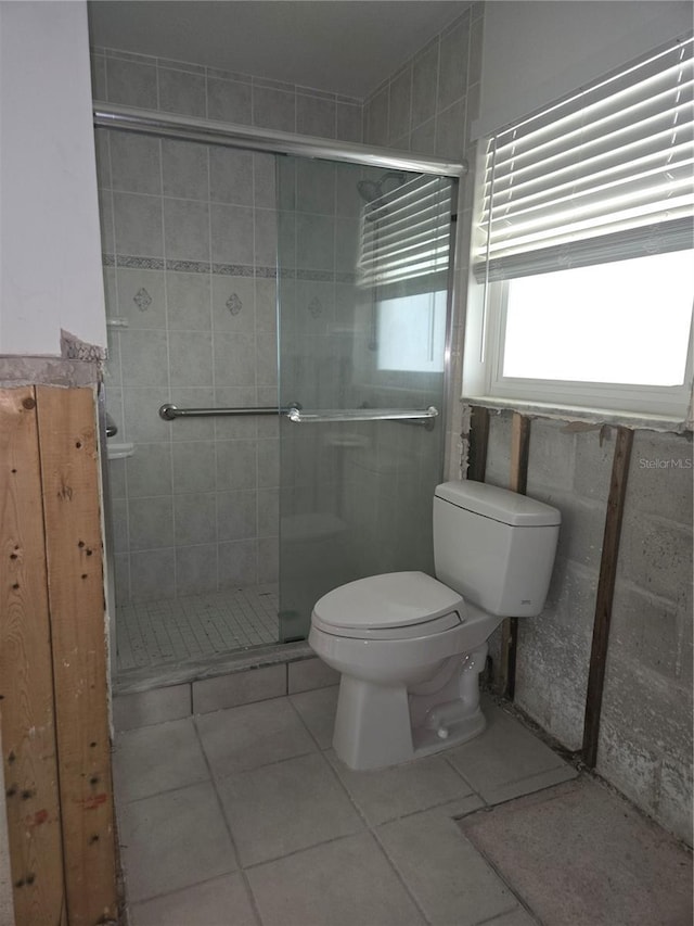 bathroom with walk in shower, tile patterned floors, and toilet