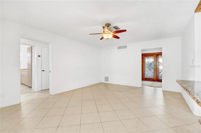 empty room featuring light tile patterned floors, french doors, and ceiling fan