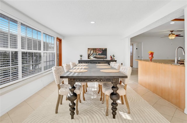 dining space with light tile patterned floors, sink, a textured ceiling, and ceiling fan