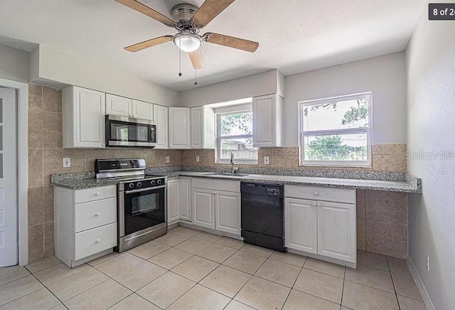 kitchen featuring stainless steel appliances, white cabinetry, sink, and light tile patterned floors