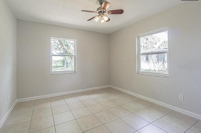 tiled empty room featuring ceiling fan