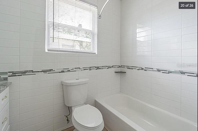 full bathroom with plenty of natural light, toilet, tiled shower / bath, and vanity