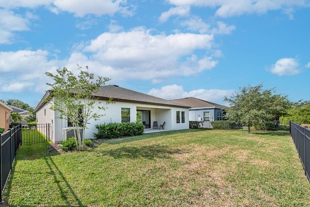 rear view of house featuring a patio area and a lawn