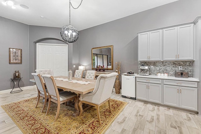 dining space featuring an inviting chandelier and light wood-type flooring