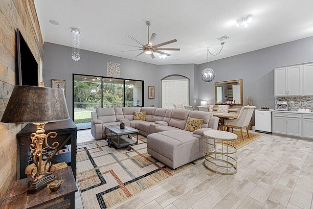 living room with a textured ceiling and ceiling fan