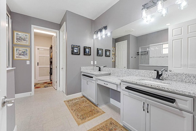 bathroom with an enclosed shower, vanity, and tile patterned flooring