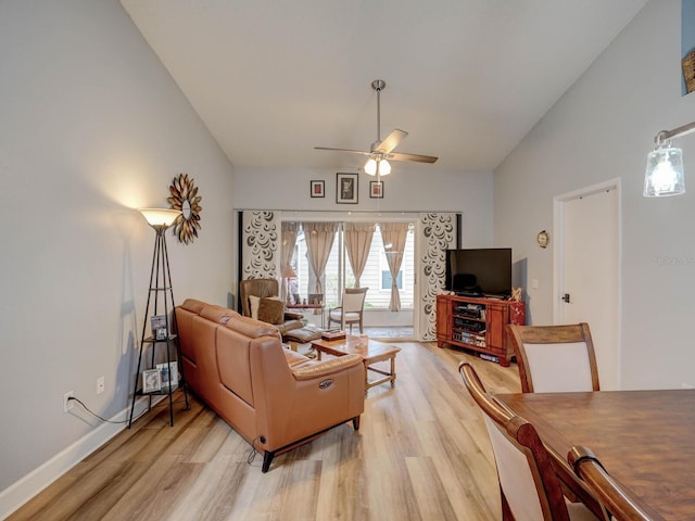 living room featuring ceiling fan, light hardwood / wood-style floors, and lofted ceiling