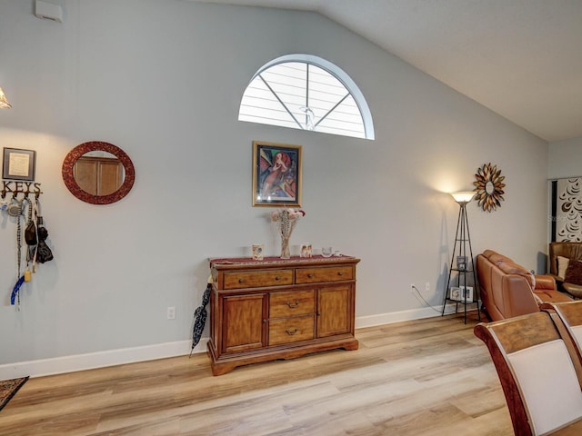 living area featuring vaulted ceiling and light hardwood / wood-style floors