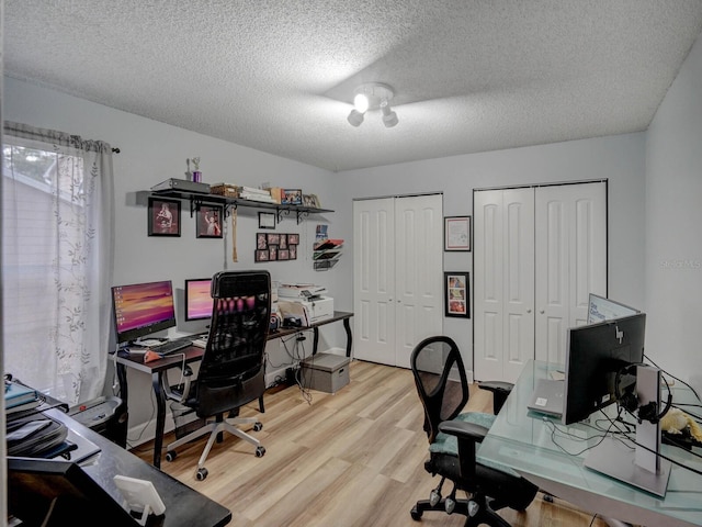 office space featuring a textured ceiling and light hardwood / wood-style flooring