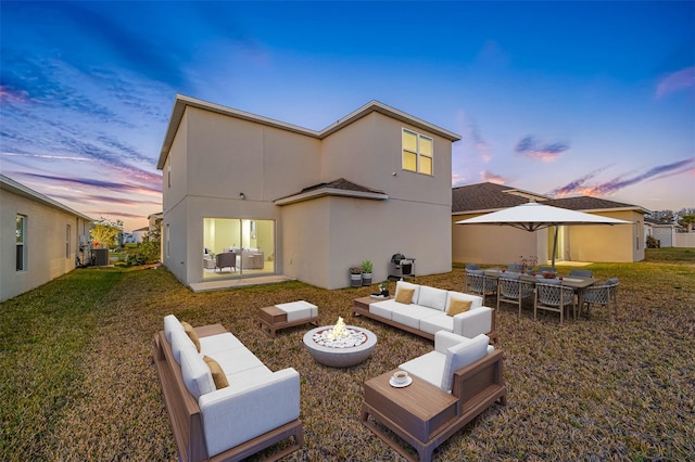 back house at dusk featuring central AC unit, an outdoor living space, a patio, and a yard