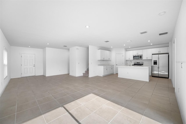 unfurnished living room with light tile patterned floors and sink