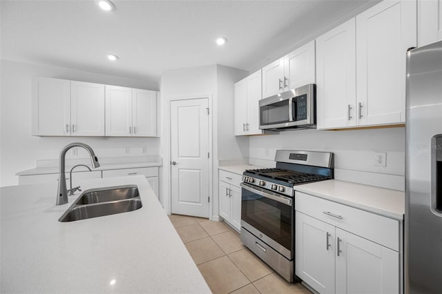 kitchen with sink, white cabinets, appliances with stainless steel finishes, and light tile patterned flooring