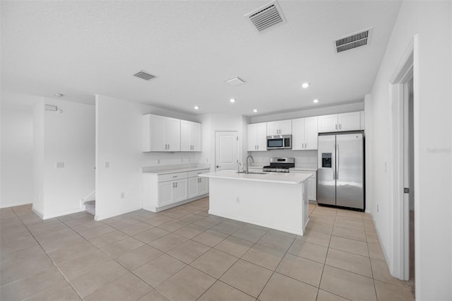 kitchen with a kitchen island with sink, sink, stainless steel appliances, and white cabinetry