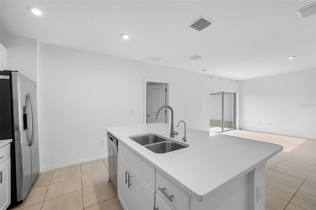 kitchen with sink, white cabinets, appliances with stainless steel finishes, and a center island with sink