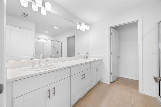 bathroom featuring vanity, tile patterned flooring, and a shower with door