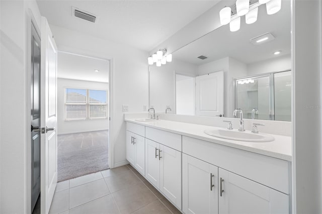 bathroom with tile patterned flooring, a shower with shower door, and vanity