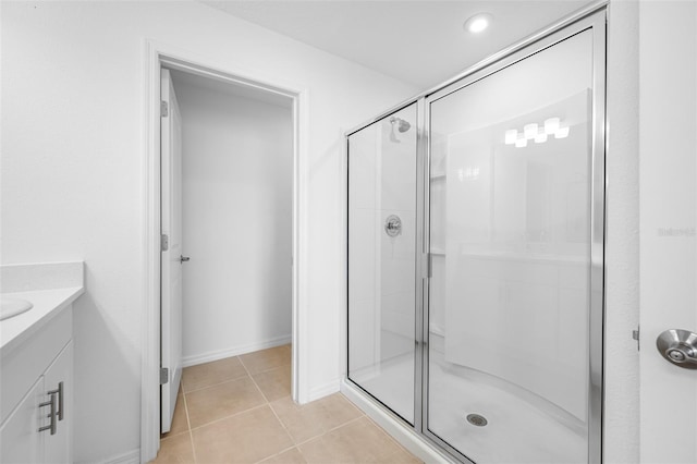 bathroom with tile patterned floors, a shower with door, and vanity