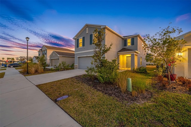 front of property with a garage and a lawn