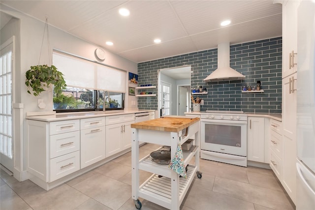 kitchen with white appliances, wooden counters, sink, white cabinetry, and extractor fan