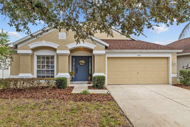 single story home with driveway, a shingled roof, an attached garage, and stucco siding