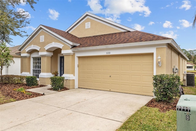 view of front of home featuring central AC unit and a garage