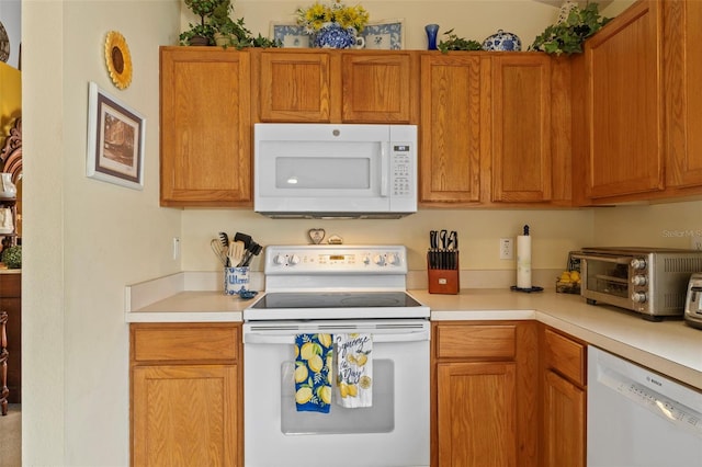 kitchen featuring light countertops, white appliances, brown cabinetry, and a toaster