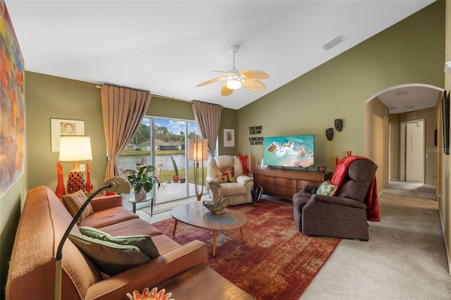 carpeted living room featuring a ceiling fan, arched walkways, visible vents, and vaulted ceiling