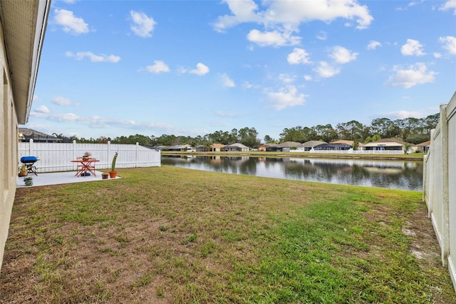 view of yard featuring a patio, a water view, and fence