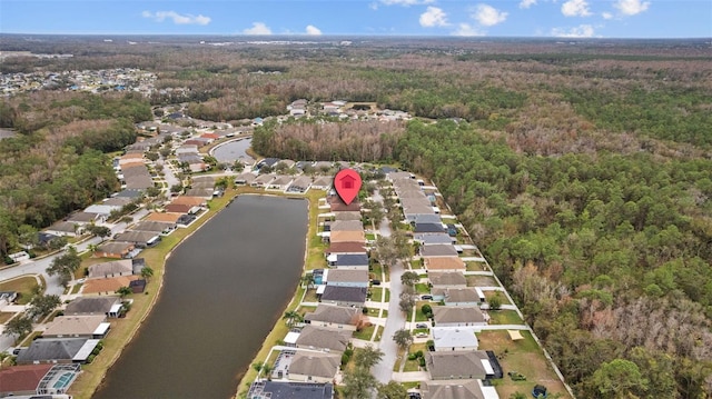 aerial view with a forest view, a water view, and a residential view