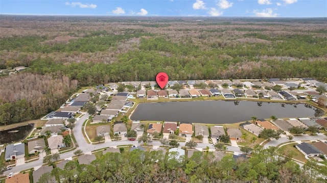 drone / aerial view with a water view, a residential view, and a view of trees