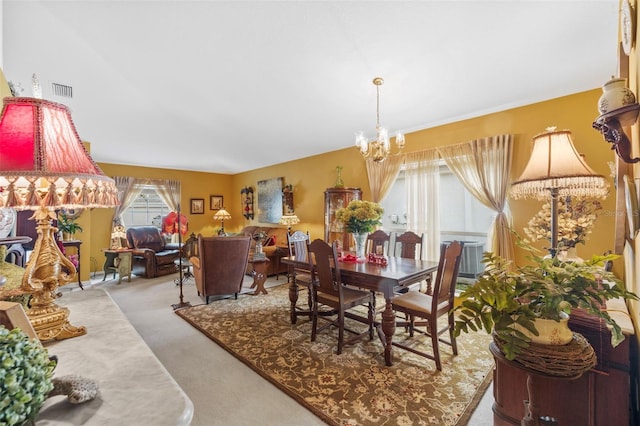 dining area featuring carpet flooring, visible vents, and an inviting chandelier