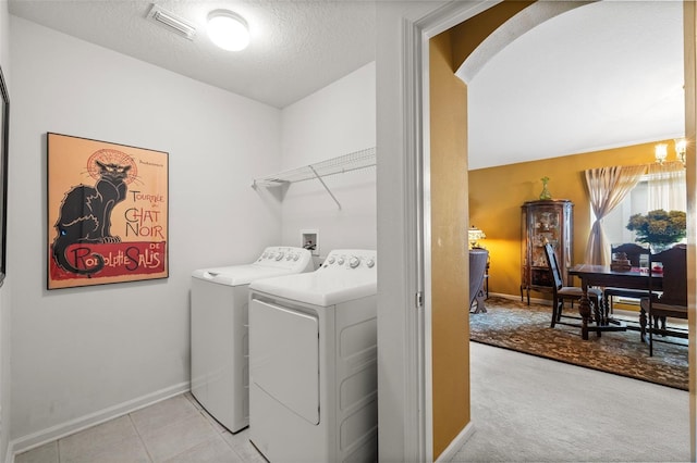 laundry area with a textured ceiling, arched walkways, washing machine and dryer, laundry area, and visible vents