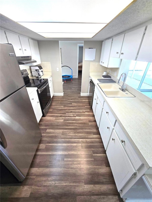 kitchen featuring sink, appliances with stainless steel finishes, white cabinets, decorative backsplash, and dark wood-type flooring