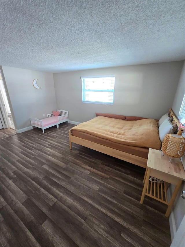 bedroom with a textured ceiling and dark hardwood / wood-style floors