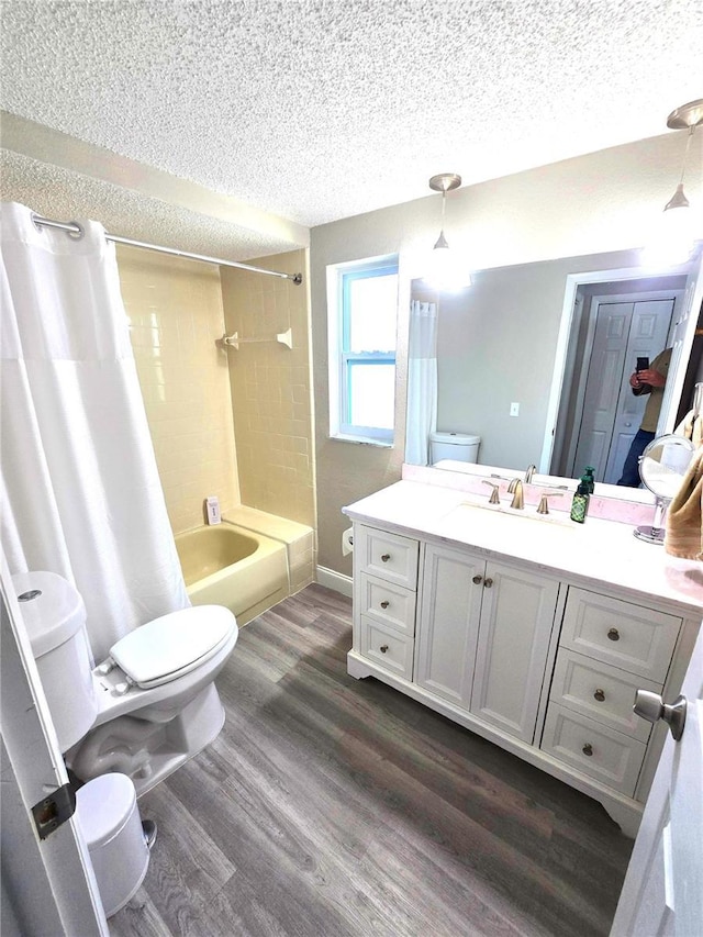 full bathroom with toilet, hardwood / wood-style flooring, a textured ceiling, shower / bath combination with curtain, and vanity