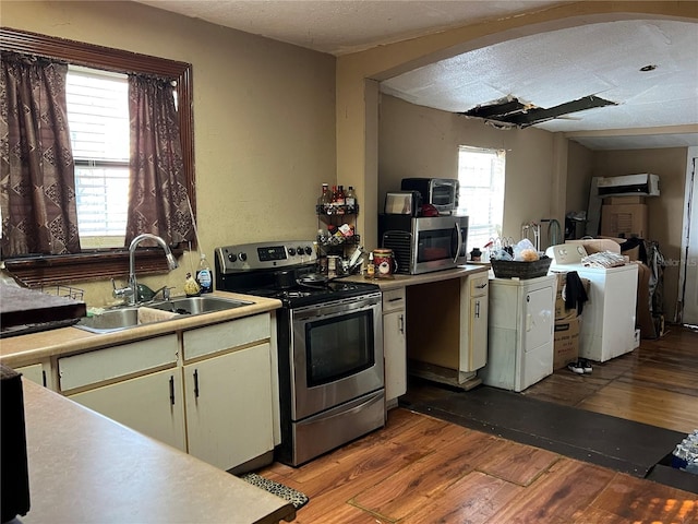 kitchen featuring stainless steel appliances, light wood-type flooring, a textured ceiling, and sink