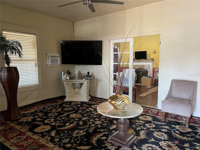 living room with an AC wall unit and ceiling fan