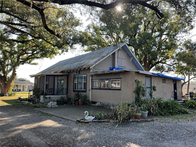 view of front of home with a sunroom and a patio