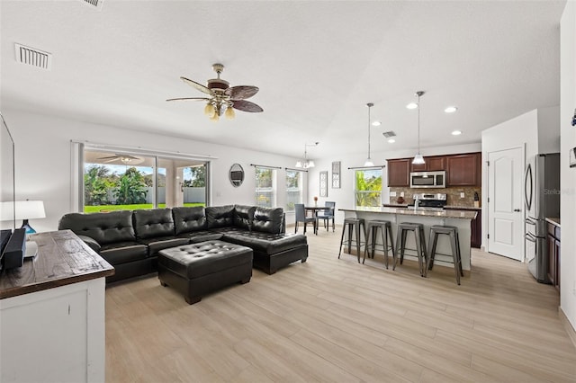 living room with sink, light hardwood / wood-style flooring, and ceiling fan with notable chandelier