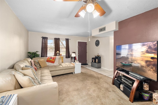 living room with light carpet, ceiling fan, and a textured ceiling